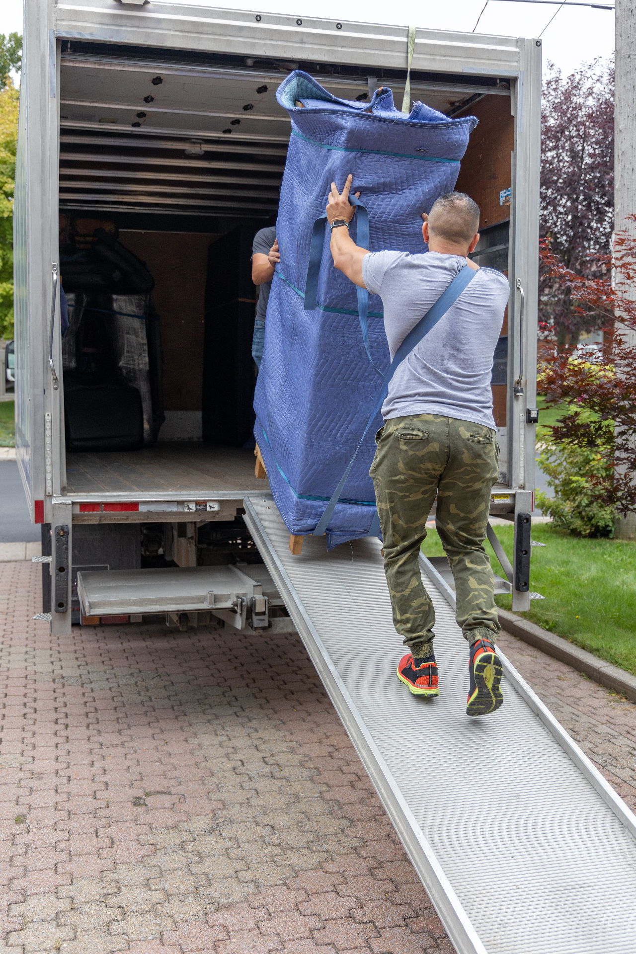 Déménageurs professionnels Déménagement Xpress transportant un sofa avec soin